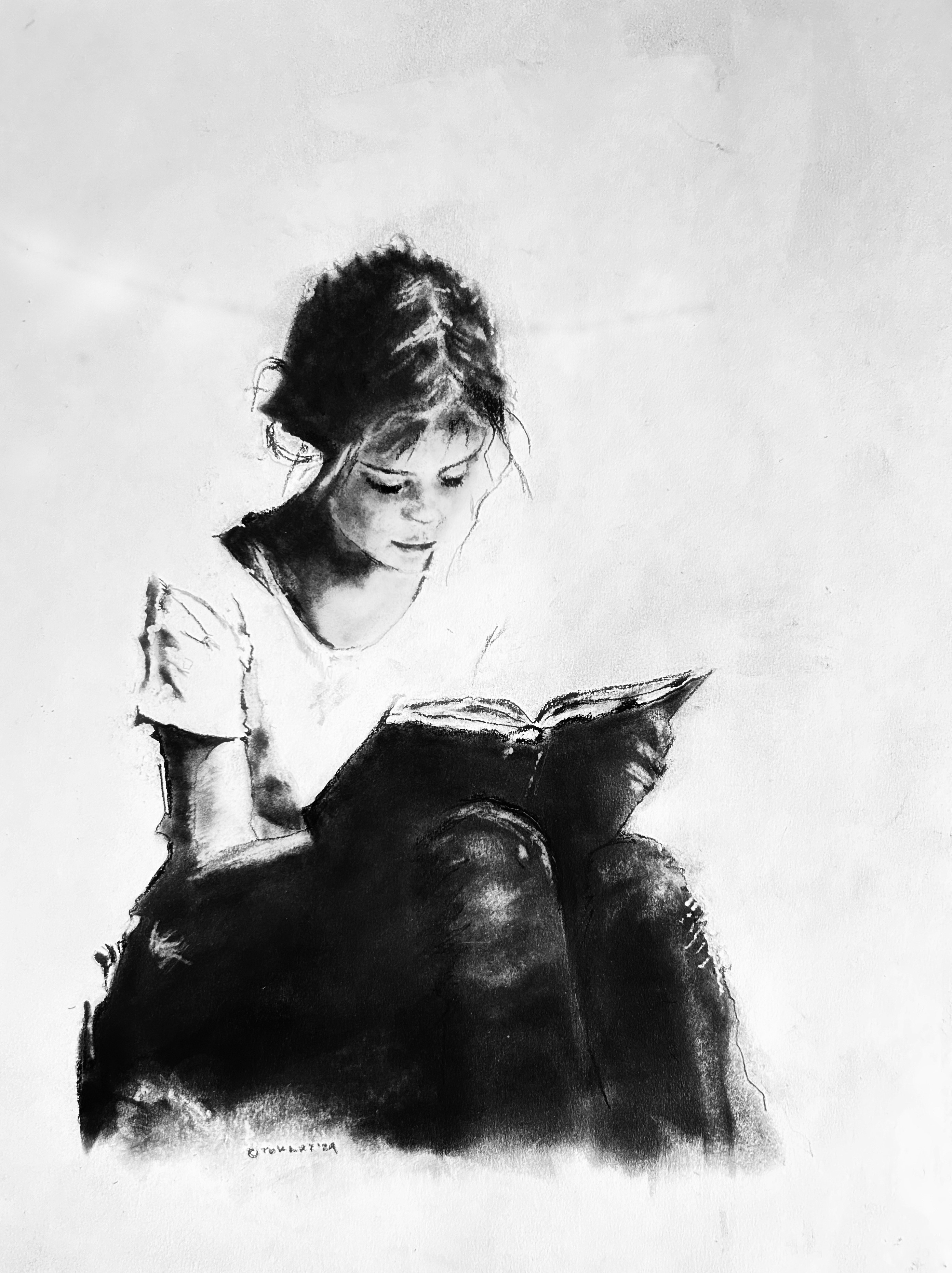 Charcoal drawing of a young girl absorbed in a 
		book, her expression reflecting deep concentration and peaceful engagement. The soft shading and 
		minimal background emphasize the tranquil, timeless experience of reading. A beautiful and emotive 
		piece for those who cherish the magic of stories and the quiet moments of immersion in a good book.